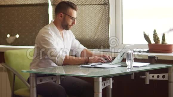 成熟的穿白衬衫的男商人把腿扔到桌子上休息时间工作休息喝咖啡休息视频的预览图