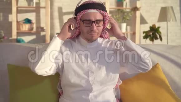 阿拉伯男子用耳机听音乐的肖像视频的预览图