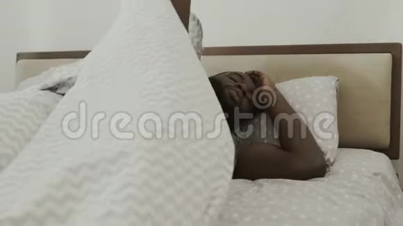 黑人睡在床上年轻男性在卧室慢慢醒来视频的预览图