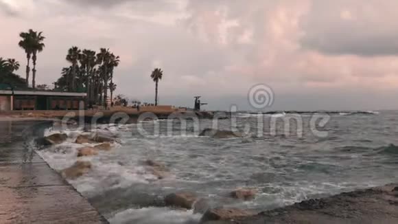 近景城市海滩暴风雨天气下的城市海滩有暴风雨长廊的旅游区巨大的海浪撞击着石头视频的预览图
