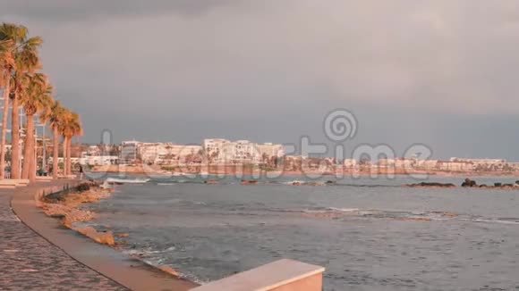 帕福斯码头塞浦路斯的旅游长廊粉红色黄昏的旅游区有吸引力的男跑运动员沿着岩石海滩训练地中海视频的预览图