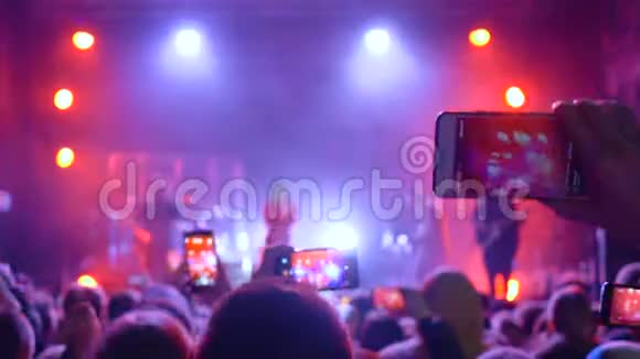 摇滚节上许多手里拿着小玩意的人在音乐会上录制视频视频的预览图