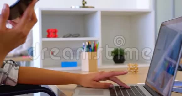 美国黑人女高管在使用笔记本电脑时使用手机说话视频的预览图