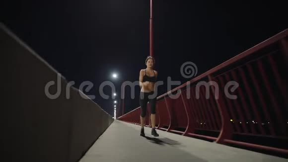 运动女人沿着夜桥跑步视频的预览图