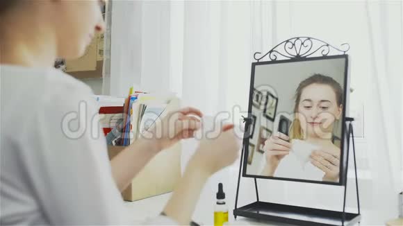年轻女子打开面膜年轻的女人做一个美容面膜护肤视频的预览图