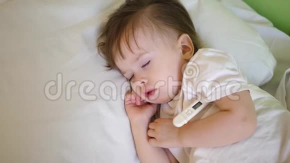 有体温计的生病孩子睡在白床上在医院病房用温度计测量儿童的体温视频的预览图