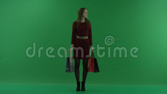 穿休闲服装的漂亮购物女人正拿着购物袋四处张望女购物者拿着购物袋视频的预览图