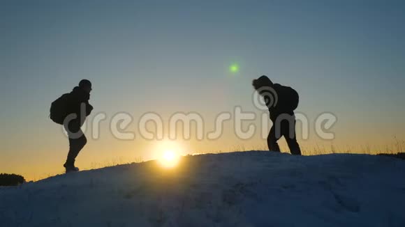 冬天人们在山顶上发现了带背包的男性游客阳光明媚山顶上的登山者视频的预览图