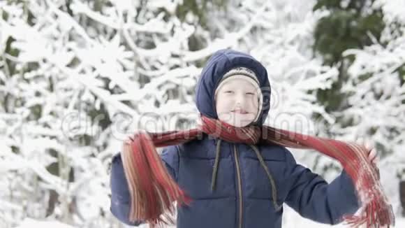冬天男孩在雪地森林里散步脖子上系着一条围巾视频的预览图