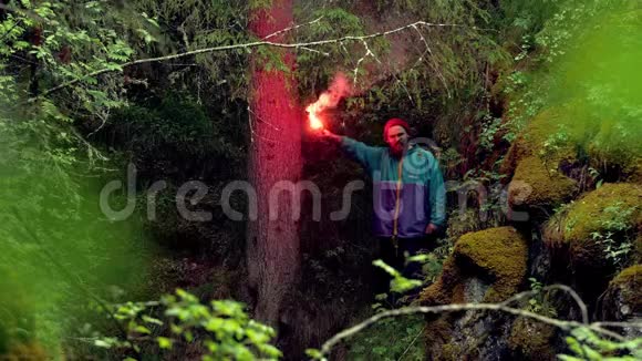 吸烟红色信号起火库存录像旅行者被困和迷失在树林里点燃了红色的火灾信号以供救援遗失视频的预览图