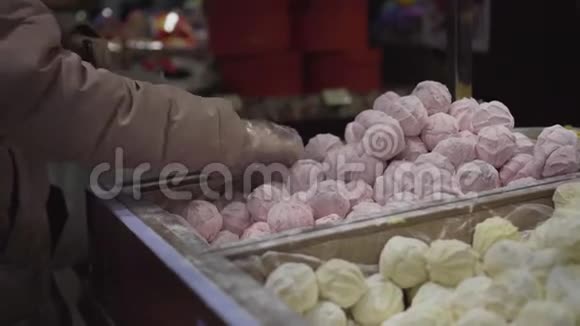双手戴手套商店里的买主正在按重量计获得棉花糖糖果女人在超市里买紫薇视频的预览图