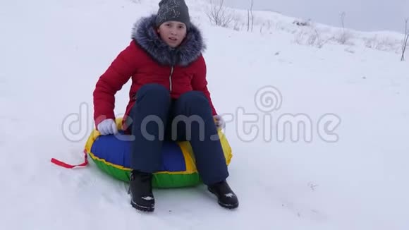 快乐的少女骑着雪碟从高山上下来边玩边笑孩子们在冬天骑雪橇视频的预览图