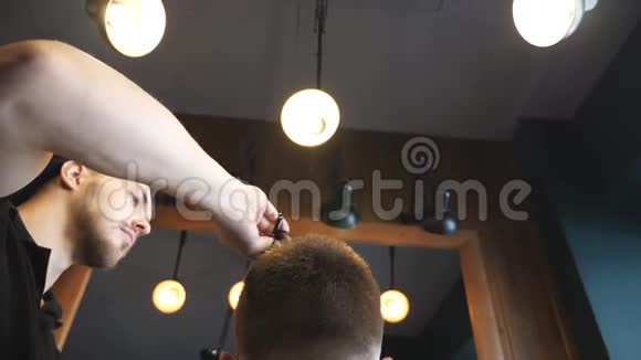 多莉拍摄的男理发师梳理他的客户头发在时尚理发店年轻人的后视图视频的预览图
