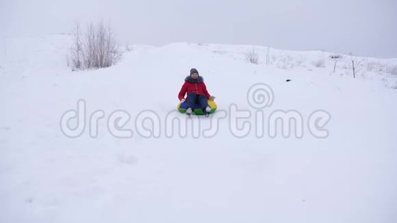 快乐的女孩骑着高高的雪山雪碟笑孩子在冬天雪橇微笑着山区度假胜地视频的预览图