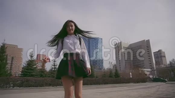 漂亮的泰国学生全身旋转站在大城市前面视频的预览图