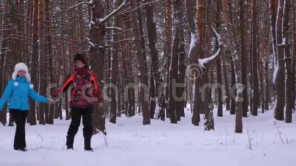 情侣们在公园里沿着雪道笑在寒冷的日子里一起散步家庭成员视频的预览图