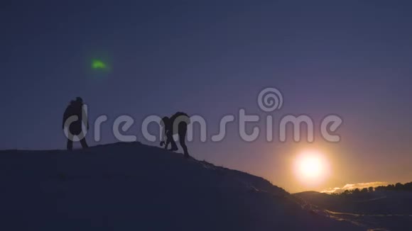 带背包的男性游客在美丽的天空和阳光的背景下爬到山顶攀登在雪山之上视频的预览图