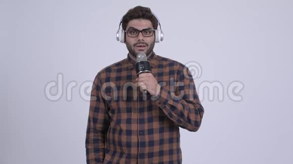 听音乐和唱歌的年轻留胡子的印度时髦男人视频的预览图