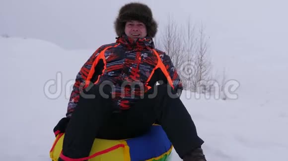 快乐的人骑着雪碟笑人在冬天雪橇微笑山区度假胜地圣诞节假期视频的预览图