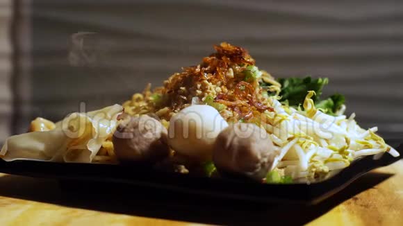 鸡面上撒上炒洋葱和蔬菜芽芥末青菜牛肉丸子鱼丸和饺子视频的预览图