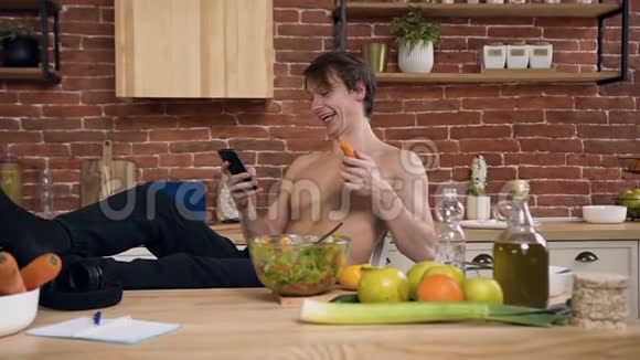 快乐的年轻人一边吃胡萝卜一边笑一边用智能手机和朋友聊天视频的预览图