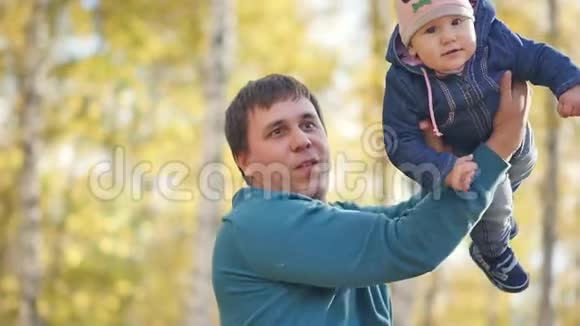 父亲带着一个小孩子在秋天公园一个年轻的爸爸正和他的小女儿在视频的预览图