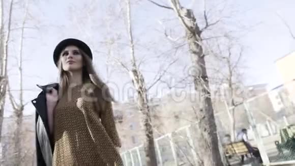 秋天穿着黑色皮夹克和一顶帽子在户外散步的时尚漂亮女人行动女模特视频的预览图
