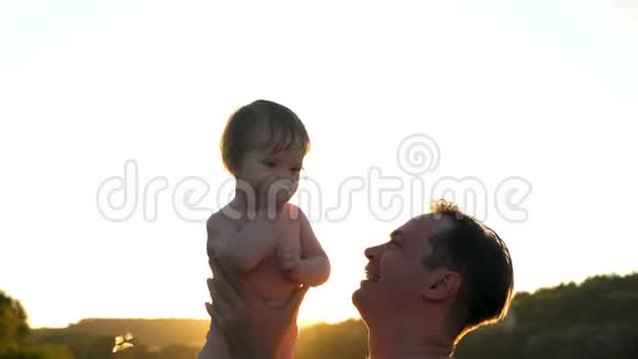 爸爸和小宝宝一起玩在夏天的时候在海滩上的日落亮点家长把孩子扔了笑了视频的预览图