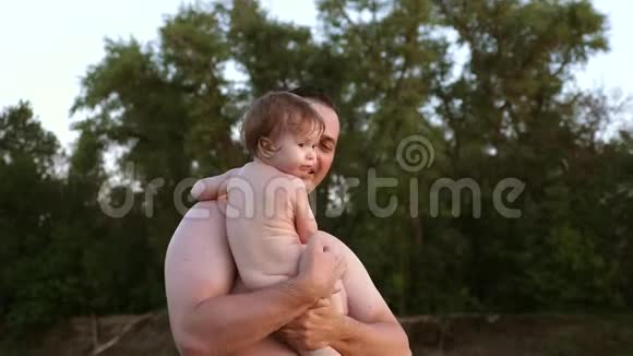 爸爸亲吻小宝宝的脸颊在海滩度假时微笑快乐的男人和孩子一起笑视频的预览图