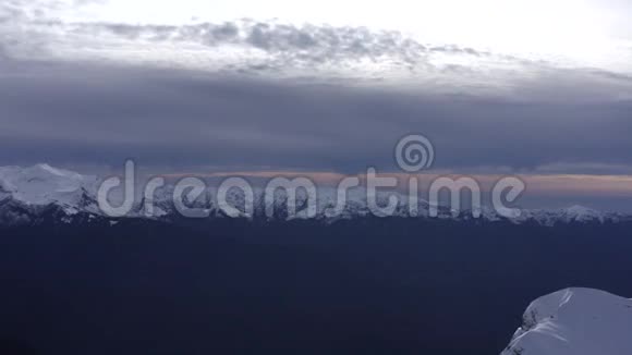 从多云地平线上飞行的无人机山和雪山的全景视频的预览图