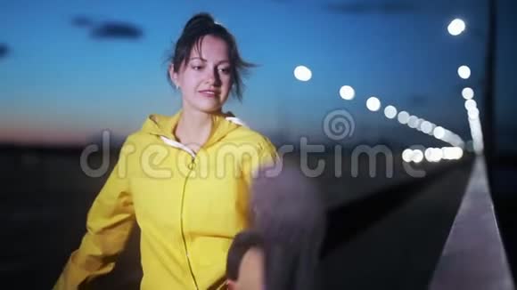 运动女子在夜间城市伸腿视频的预览图