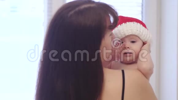 孩子戴着圣诞老人的帽子妈妈抱在怀里圣诞老人小宝宝和妈妈一起玩圣诞假期视频的预览图