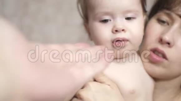 爸爸伸出手给一个小孩子妈妈把婴儿抱在怀里视频的预览图