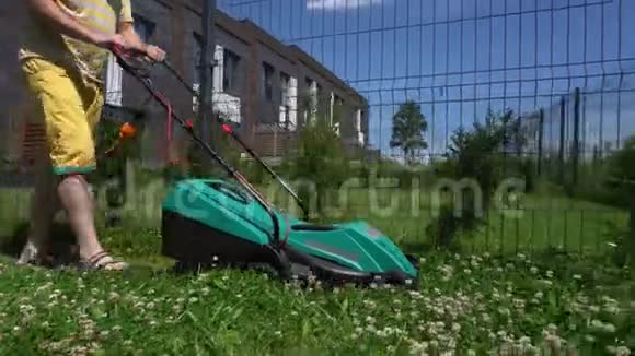 男人用割草机在自家花园院子里割草万向节运动视频的预览图