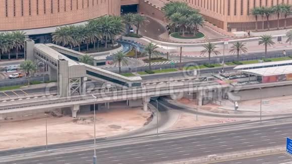 在阿联酋迪拜的迪拜码头从有轨电车停止时间推移到步行桥的购物中心附近的空中交通俯视视频的预览图