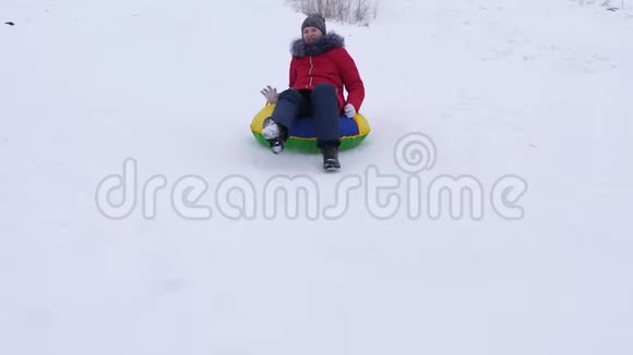 德维什卡从雪山上骑到雪碟上微笑着在避暑山庄休息的青少年快乐的孩子视频的预览图