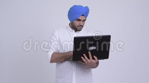 年轻的印度锡克族长胡子的人在使用笔记本电脑时思考视频的预览图