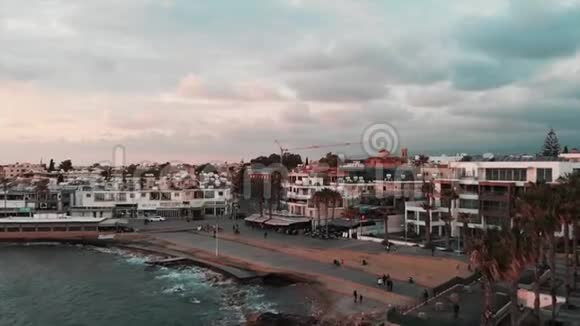 无人机拍摄的旅游地区在城市与码头和咖啡馆游客在码头附近散步并拍照空中无人机视野视频的预览图