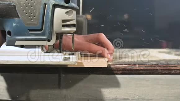 男木匠他的手在家里的车间里做电锯慢动作切割木制部件视频的预览图