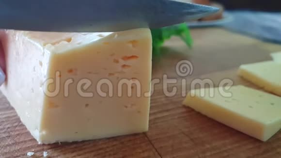 在木制背景上切奶酪切刀厨房营养慢动作视频的预览图