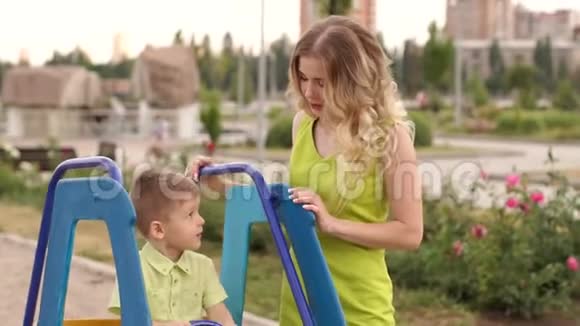 那个孩子坐在操场上一辆儿童车的车轮前视频的预览图