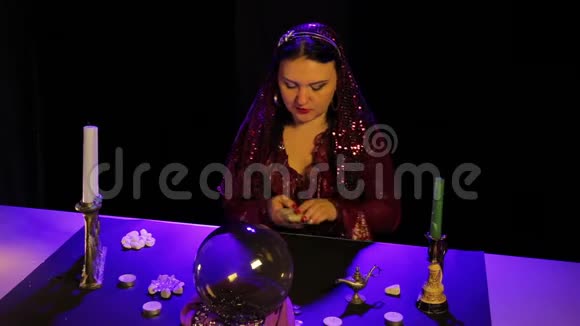 在烛光下的神奇沙龙里一个吉普赛人洗牌算命牌视频的预览图