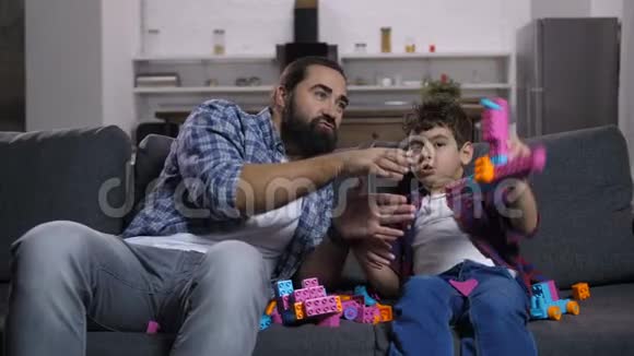 兴奋的爸爸和孩子玩五颜六色的玩具视频的预览图