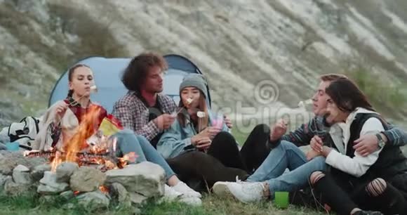 多文化的朋友一起旅行愉快坐在篝火前一起喝酒视频的预览图