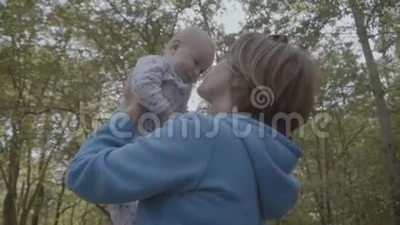 祖母抬起头用慢动作亲吻快乐的婴儿视频的预览图