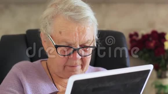 科技年龄和人的概念快乐的老年妇女与平板电脑在家视频的预览图