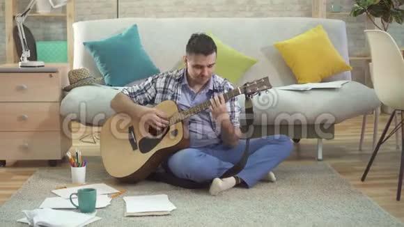 年轻有创造力的音乐家弹吉他写歌视频的预览图