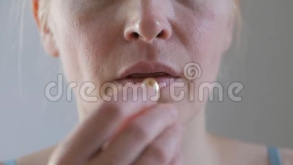 中年妇女的特写镜头吞咽药丸喝一杯水视频的预览图
