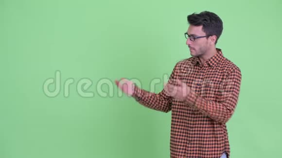 一位年轻的西班牙裔时髦男人展示了一些东西并竖起了大拇指视频的预览图