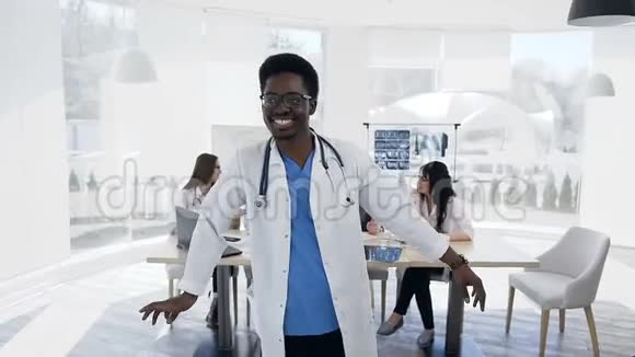 快乐的非洲男性在工作日与科克团队的背景在医院跳舞视频的预览图